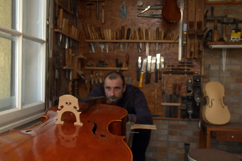 Aurelian lângă un violoncel lăcuit, lucios
